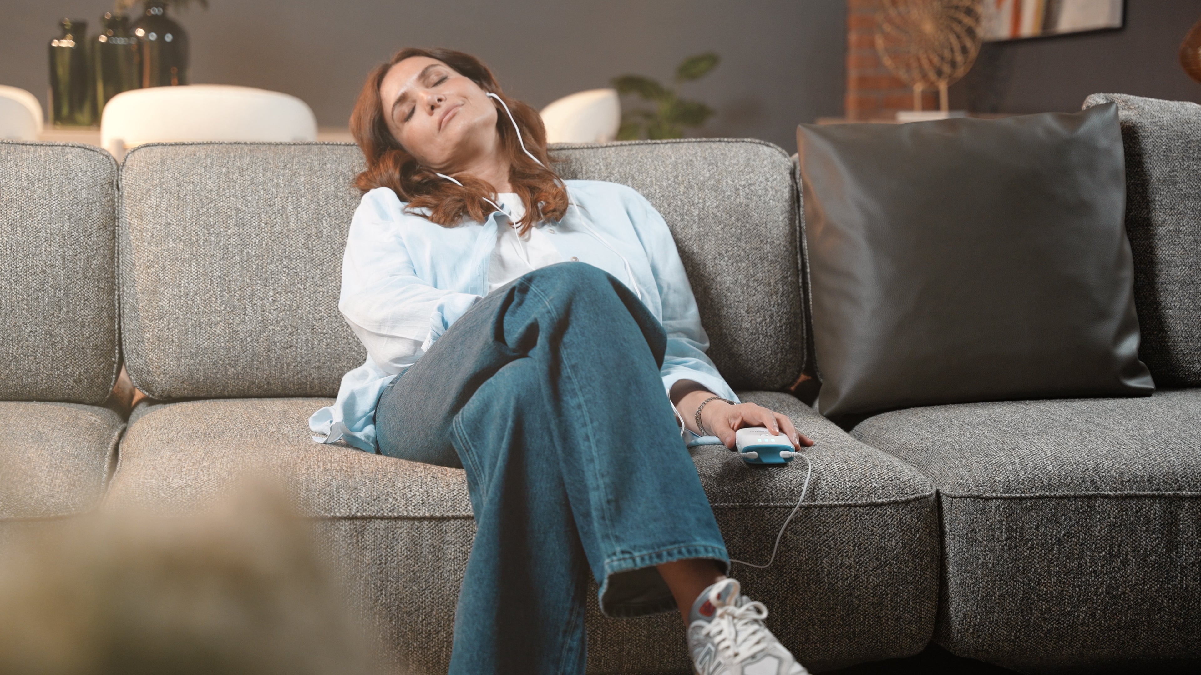 A woman relaxing on a sofa during a Vagustim V2 session