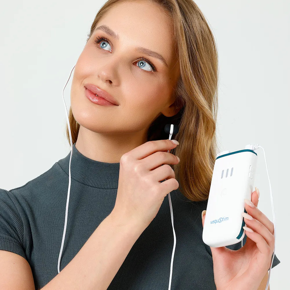 Woman holding the Vagustim V2 device with an earset in her ear